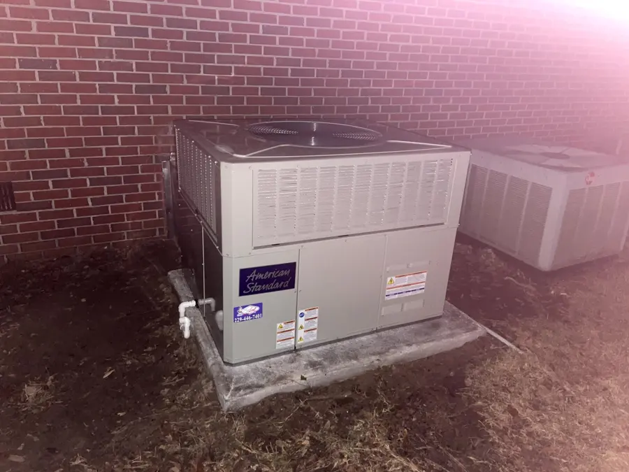 Installed package HVAC unit beside a brick wall